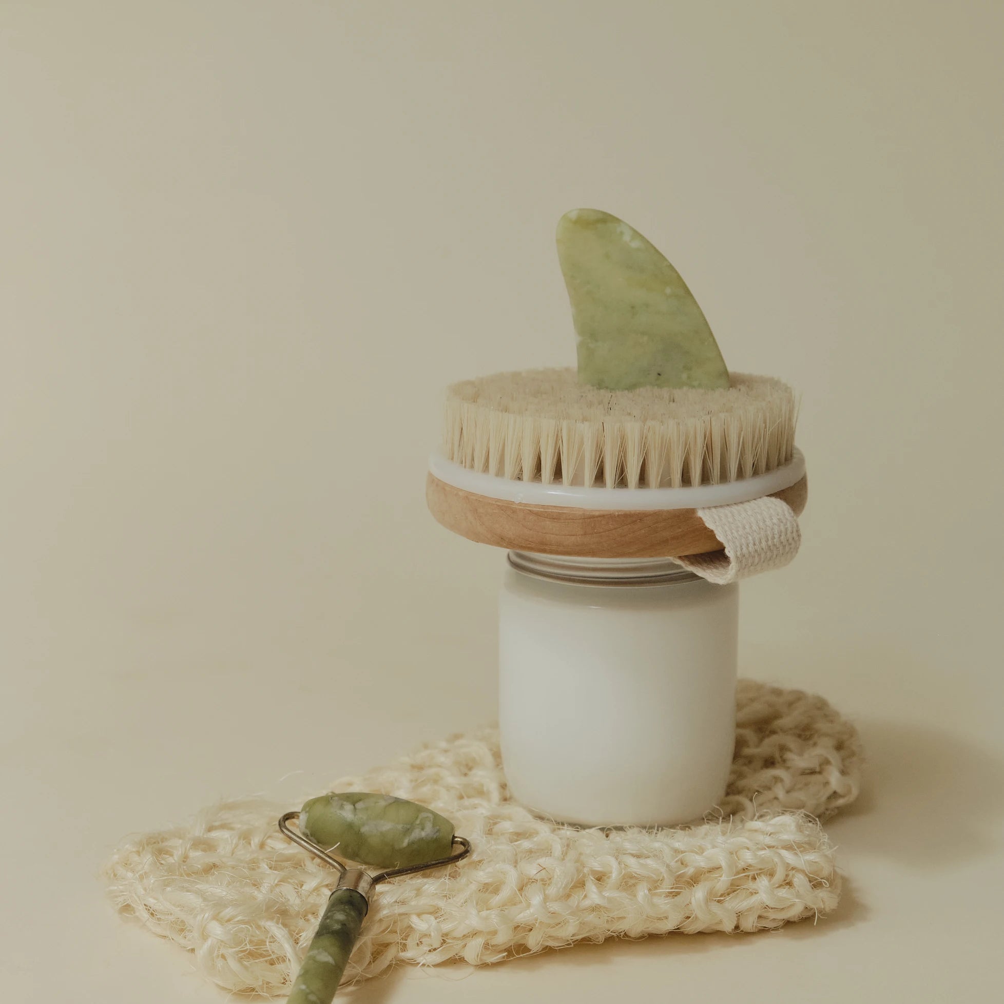 An image of a dry body brush and a green facial roller