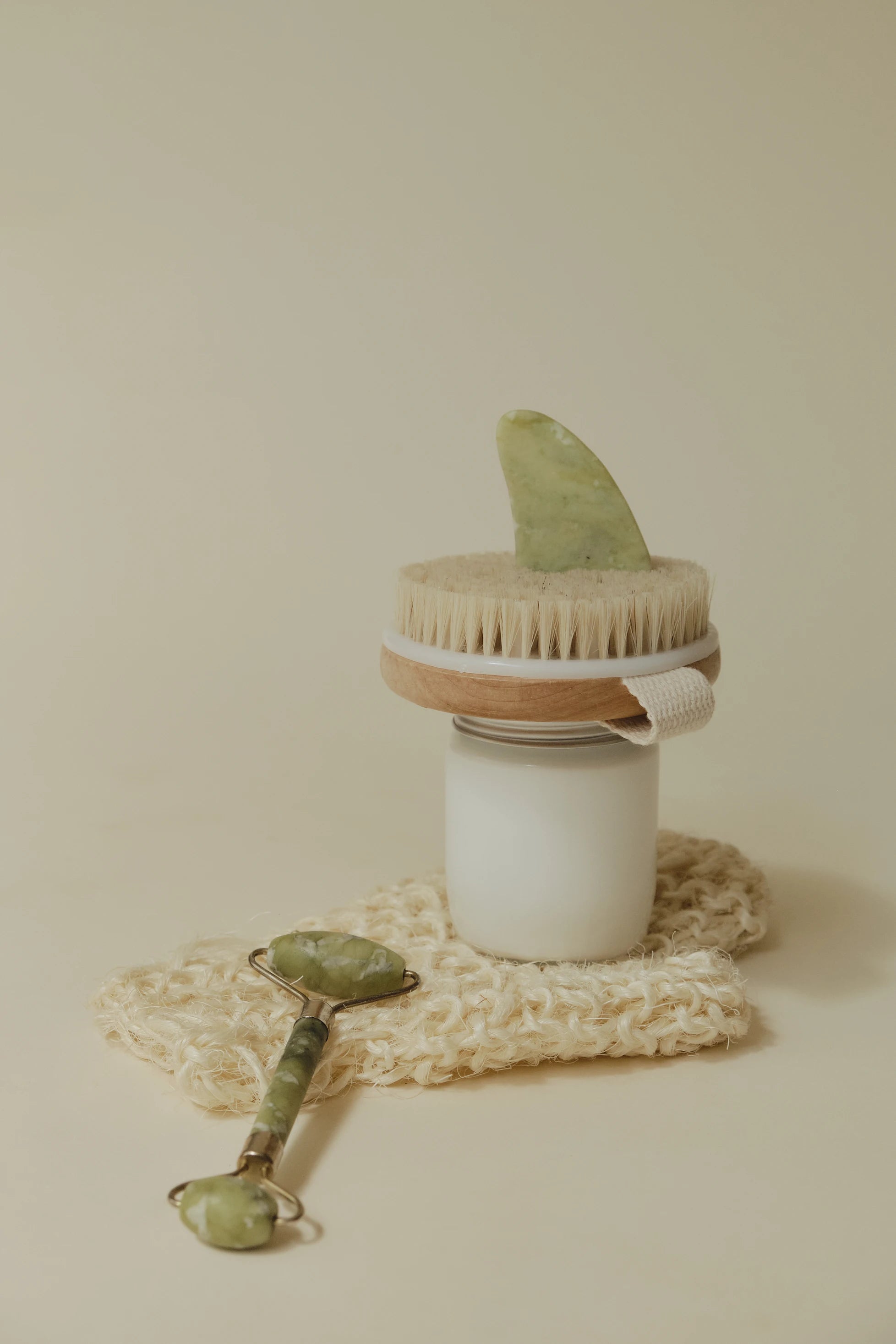 An image of a dry body brush and a green facial roller